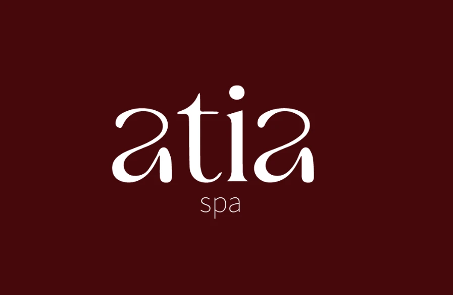 Logotipo de Atia Spa en blanco sobre fondo vino
